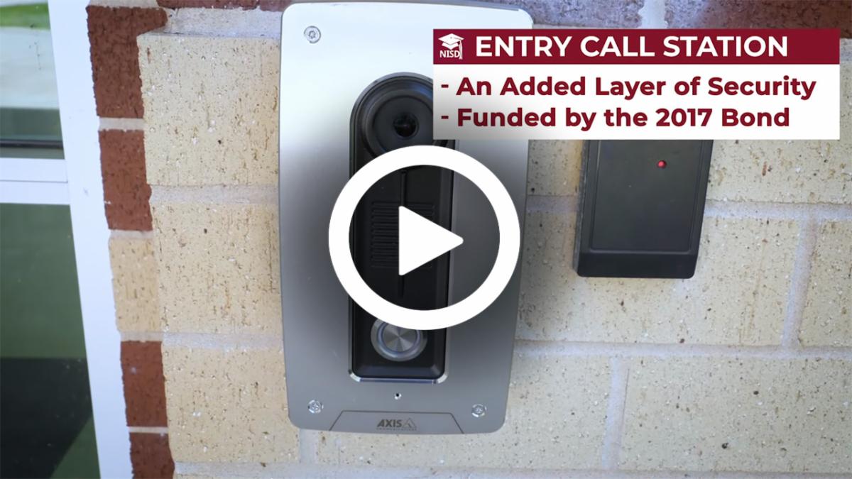 A video play button on top of a screen capture of a video displaying the entry call station at a school