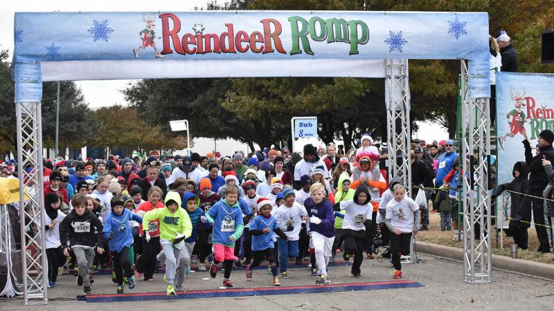 A large group of participants begin the Reindeer Romp, crossing the start/finish line