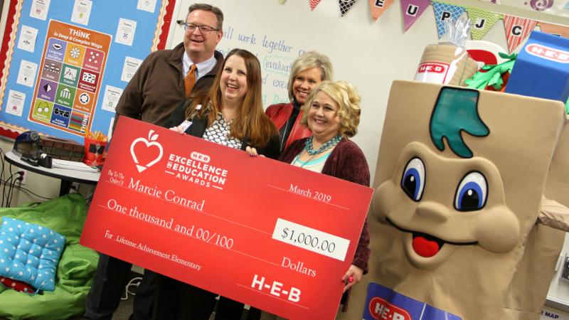 Marcie Conrad poses for a photo with school and district officials