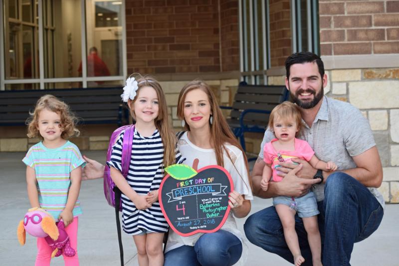 A family poses for a first-day photo in front of Curtis Elementary