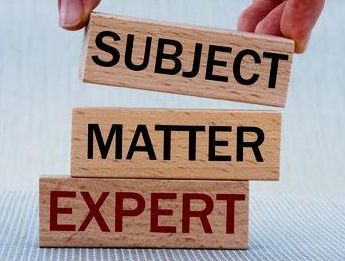 Women s hand folds wooden bars with words SUBJECT_ MATTER_ EXPERT. Business concept