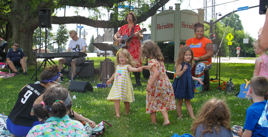 Children dancing to live performers at town square