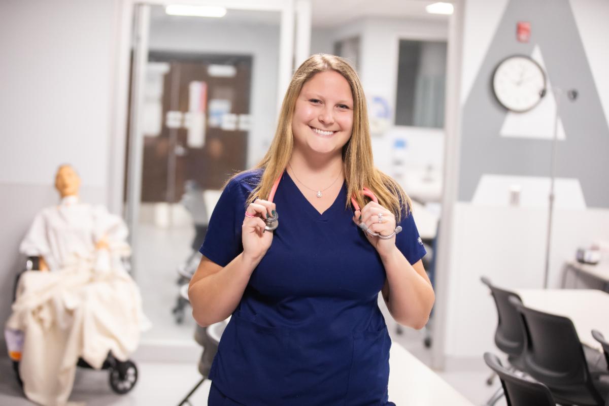 A nurse wearing blue scrubs