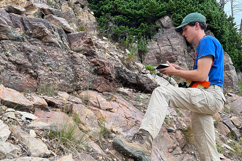Zachary Ellia graduate student at Idaho State University examines an exposure of the Great Unconformity in the Teton Range