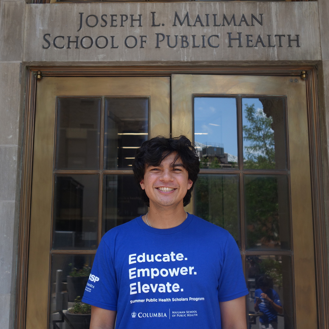 Elijah Escobedo poses for a photo in front of a building on the Columbia University campus.