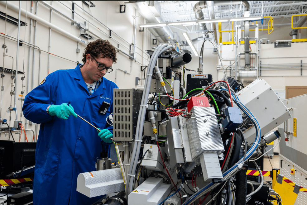 Mauseth making an adjustment to an instrument on the unshielded FIB-SEM to enable the next experiment.
