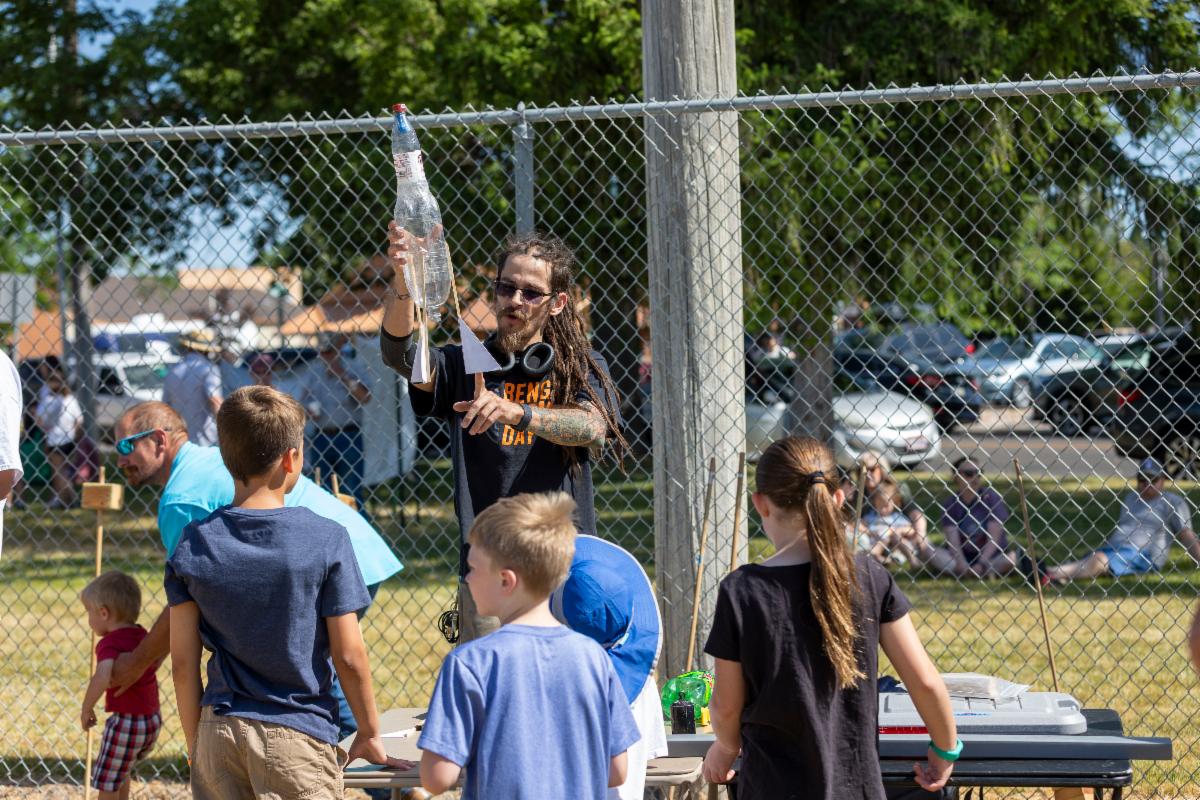 A volunteer helps water rocket scientists build their water rocket.