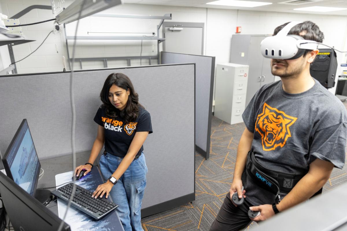 Right Reece Foulkrod ISU student plays Lit-VR a virtual reality game based in 17th-century London while Farjana Eishita assistant professor at Idaho State University looks on