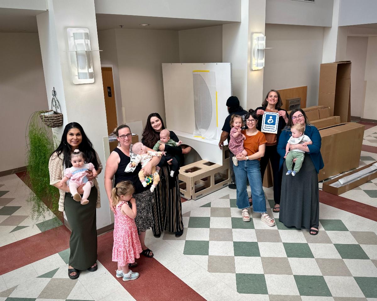 New mothers working at ISU pose for a photo in front of one of the new lactation pods
