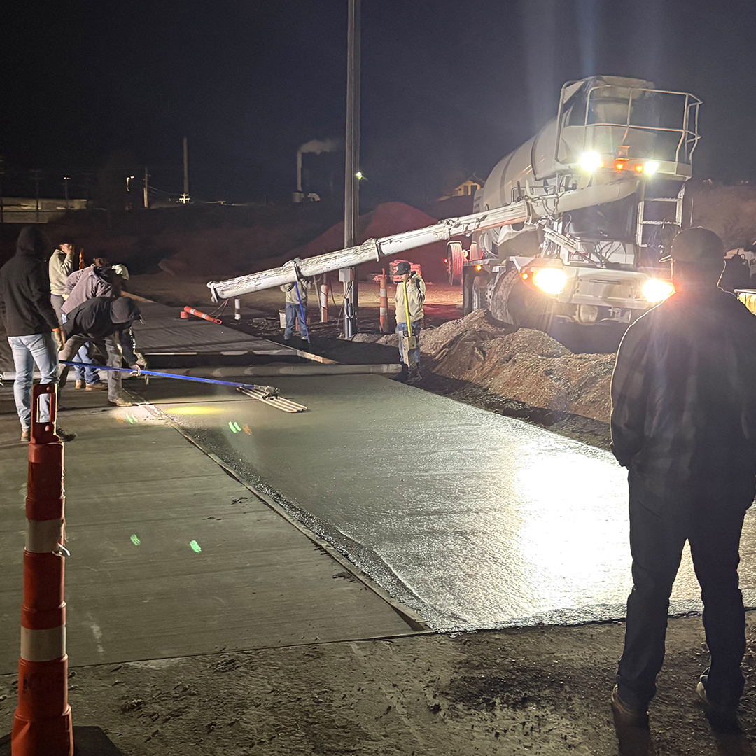 Crew members perform finishing work on the first Sweetcrete pad. This innovative concrete blend uses less cement and is cheaper to produce while still being as strong as conventional concrete developed at Idaho State University.
