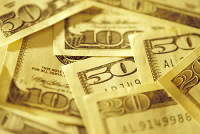Picture of a loose pile of cash - $100, $50, and $20 bills, arranged for the photo in such a way that the corners with the bill denominations are visible