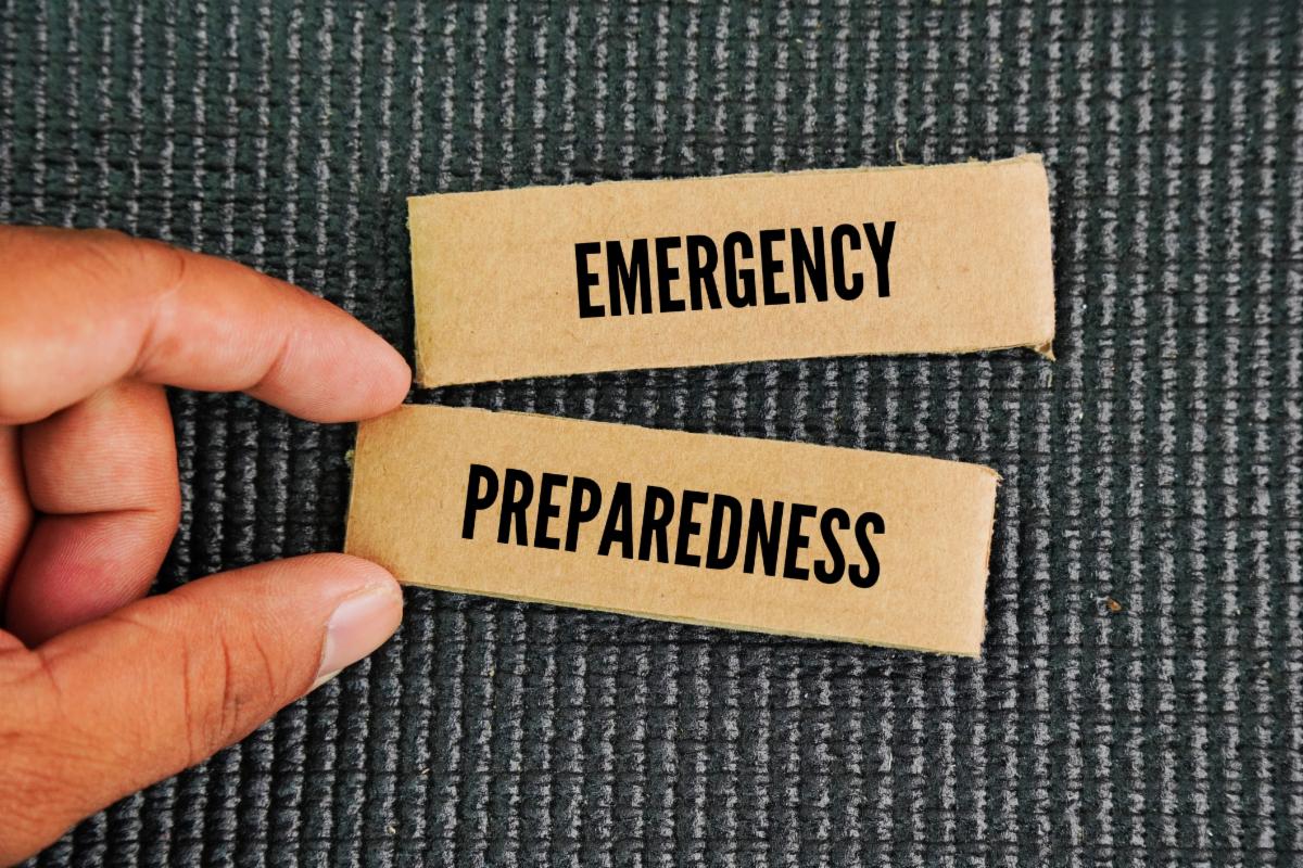 Two wooden blocks with the words " Emergency Preparedness" on them being held by a hand.