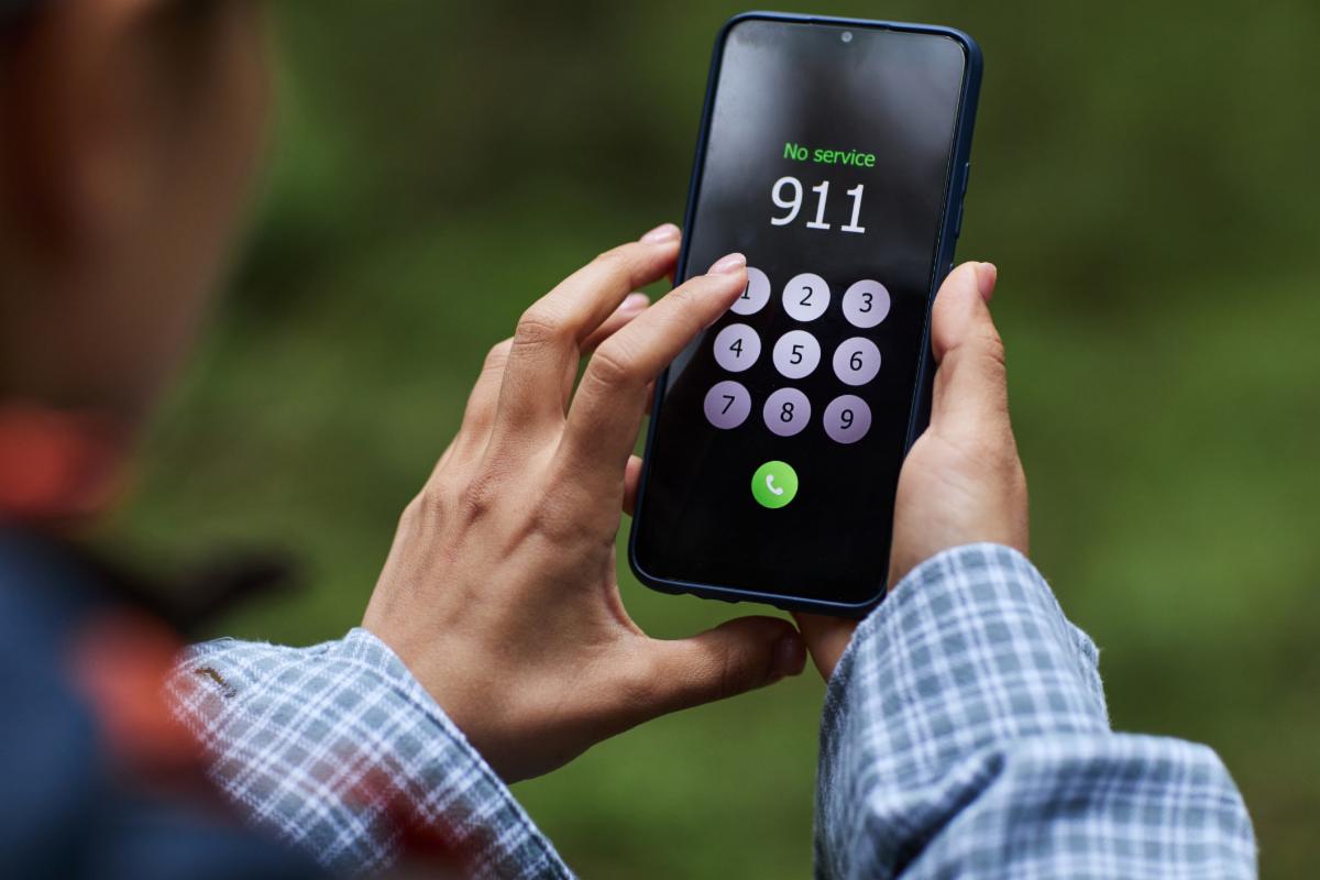 person dialing 911 emergency call on cellphone.
