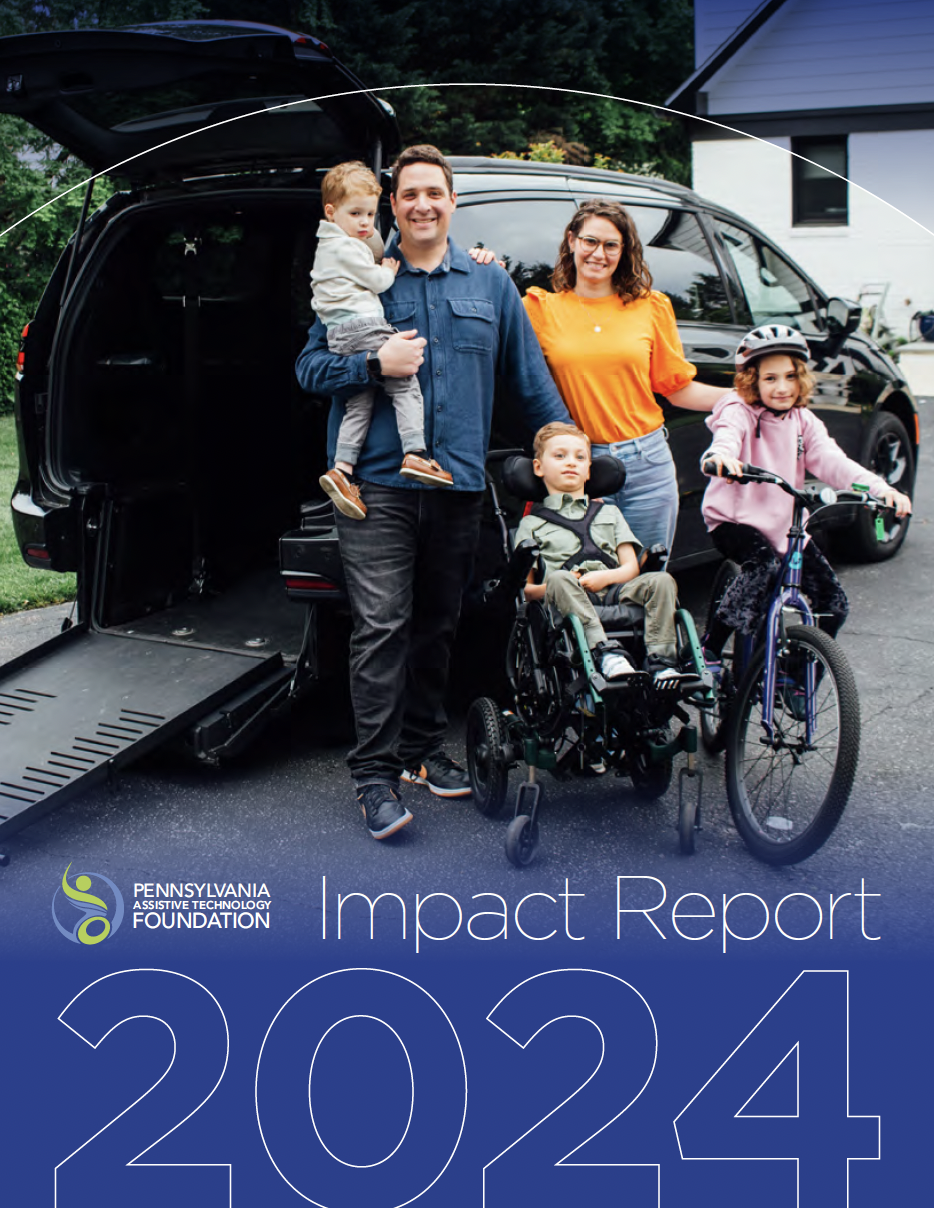 Five people are outside of a black adapted van. They include a man holding a young boy, a woman, a young girl on her bike, and a young boy in a wheelchair.