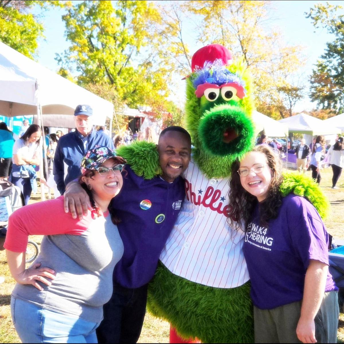 Phillies Phantic mascot with two women and one man.