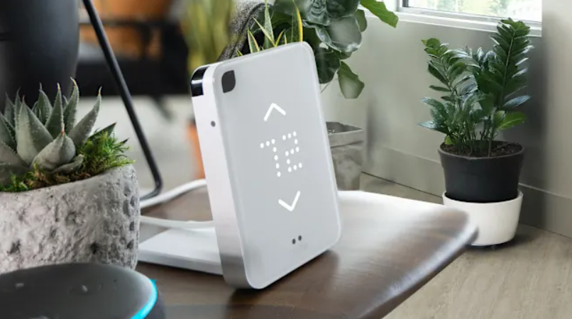 A smart AC controller that is sitting on a table and reads a temperature of 72.
