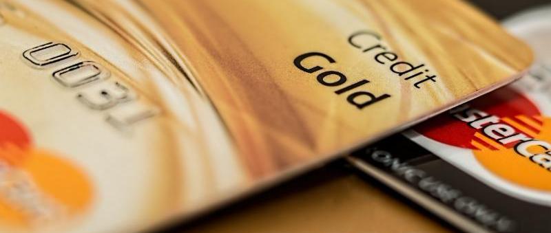 Close up of three credit cards piled on top of each other. One says Credit Gold_ another shows the MasterCard symbol_ and another says VISA.
