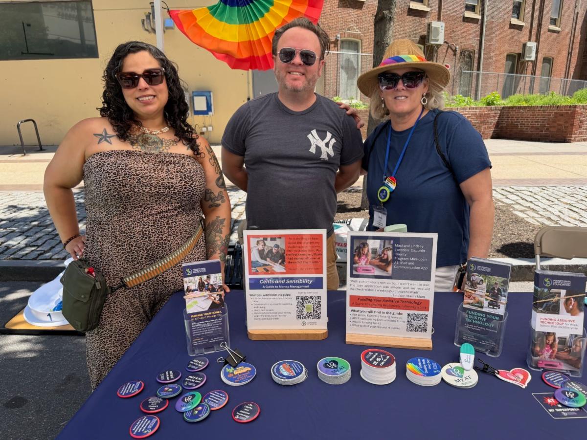 Wendy Furman, Will Hall, and Wendy David standing behind PATF's resource table.