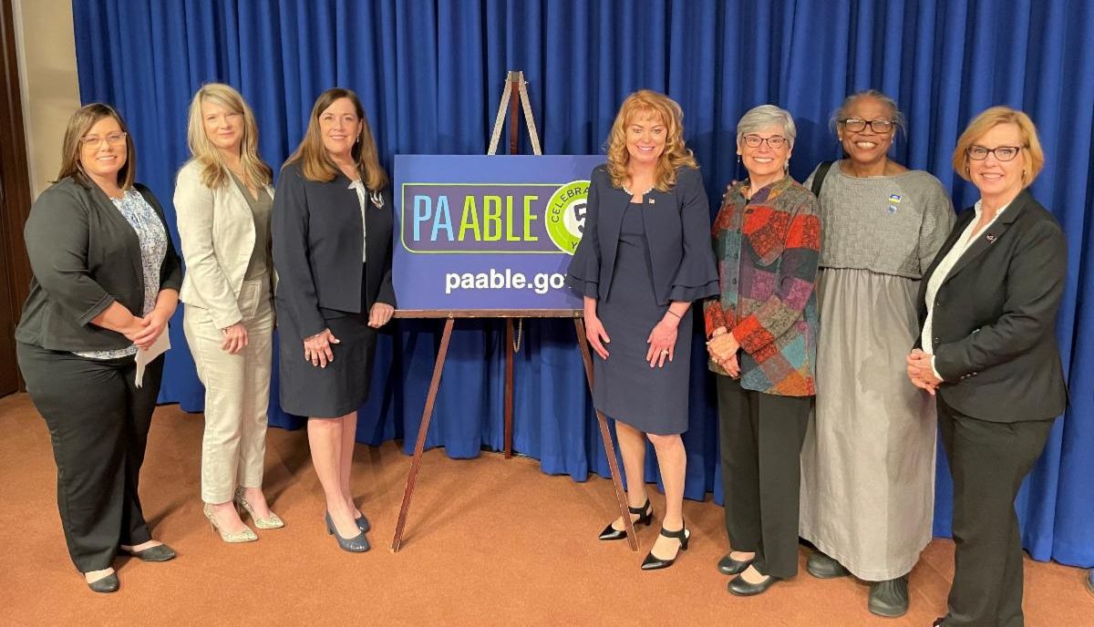 Susan Tachau stands with legislators at PA ABLE anniversary press conference.
