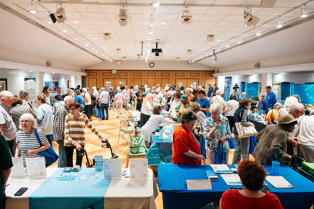 A photo of the event room filled with vendors and attendees.