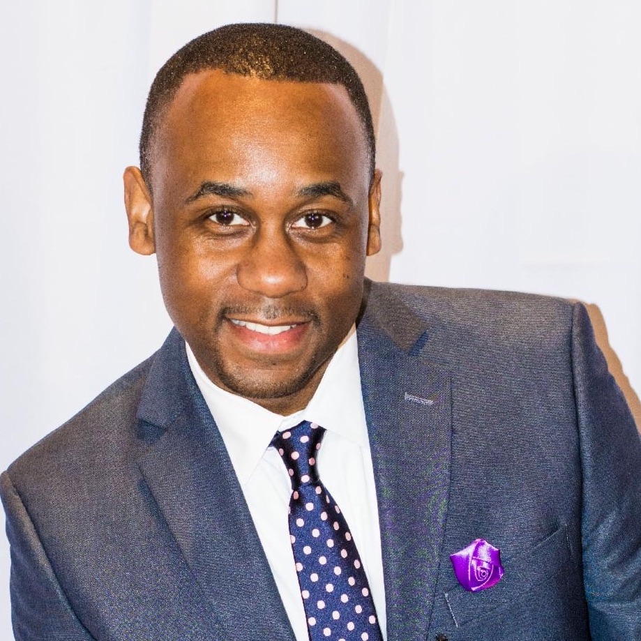 Quintin Cliett in blue suit and tie, smiling