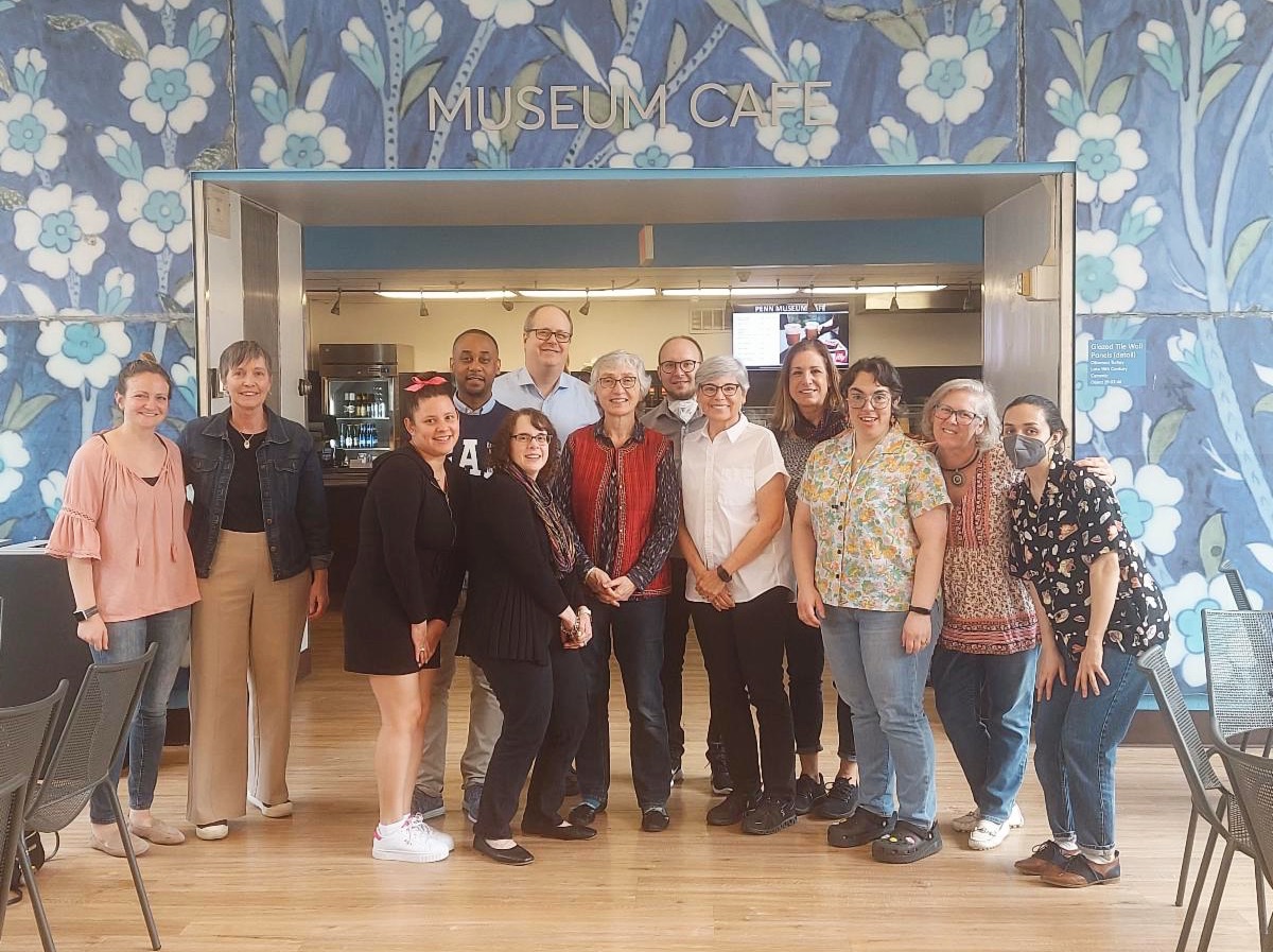 Thirteen PATF staff members standing in the cafe area of the Penn Museum