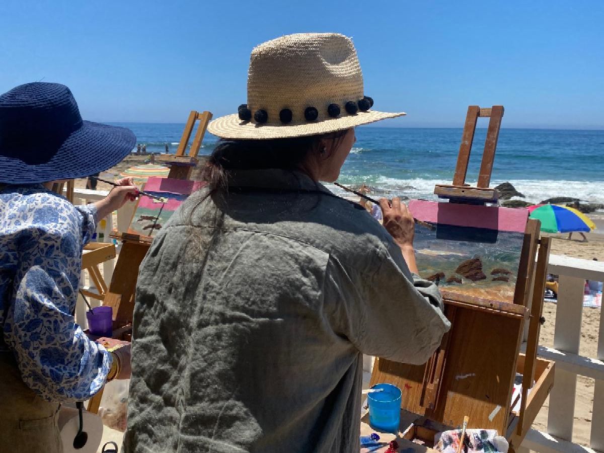 Woman painting on an easel at the beach