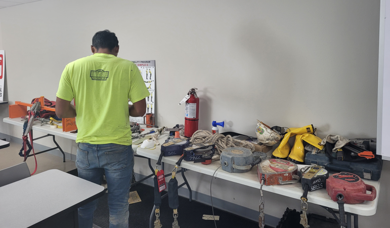 A student stands beside table of work equipment
