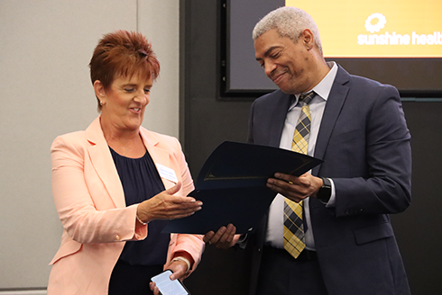 Chris Simmons presents Carole Maytas, vice president of operations for Sunshine Health,