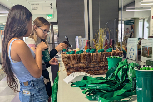 Students at a table choosing free USF items at Week of Welcome event