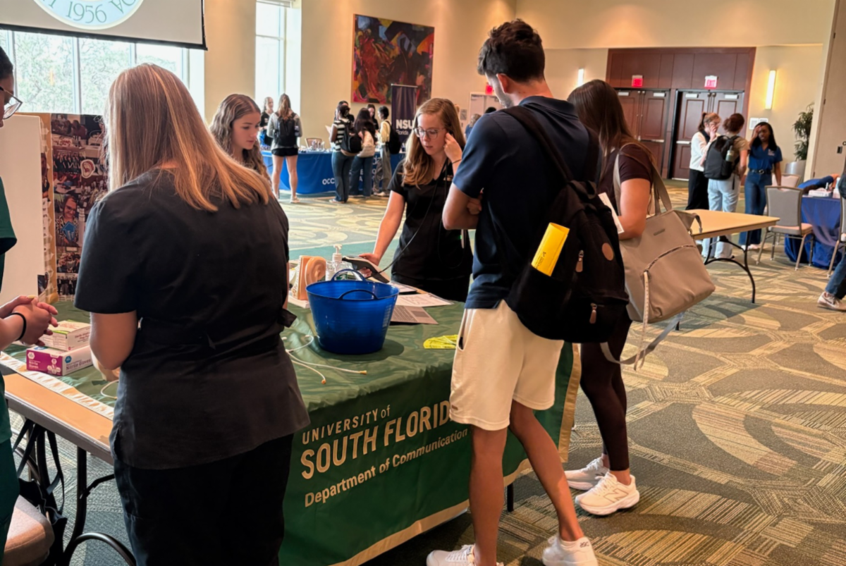 Students standing at a booth looking at information