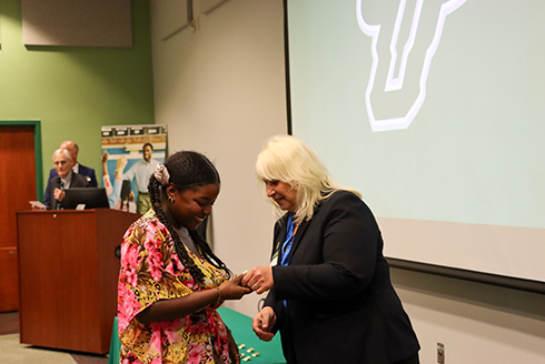 BHC graduate student receives pin from Nickie Zenn