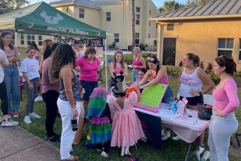 Trick or Treat with the Greeks tabling Barbie theme with kids playing games in 2023