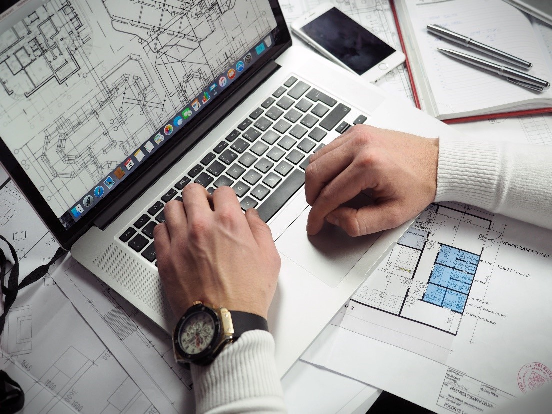 hands on laptop and building plans