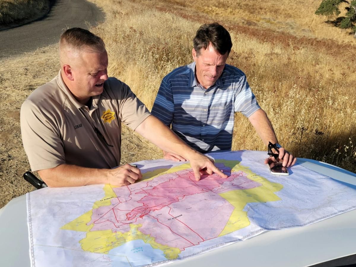 El Dorado County Sheriff Lt Jeff Leikauf shows the map of the Caldor Fire's path of destruction to Board Member Gaines 