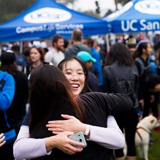 Two women hugging at the AIDS fair