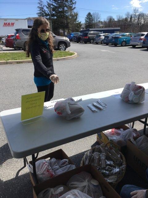 Person picking up bagged lunch outside