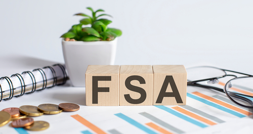 FSA word on wood blocks concept with chart_ coins_ notebook and glasses.Business concept