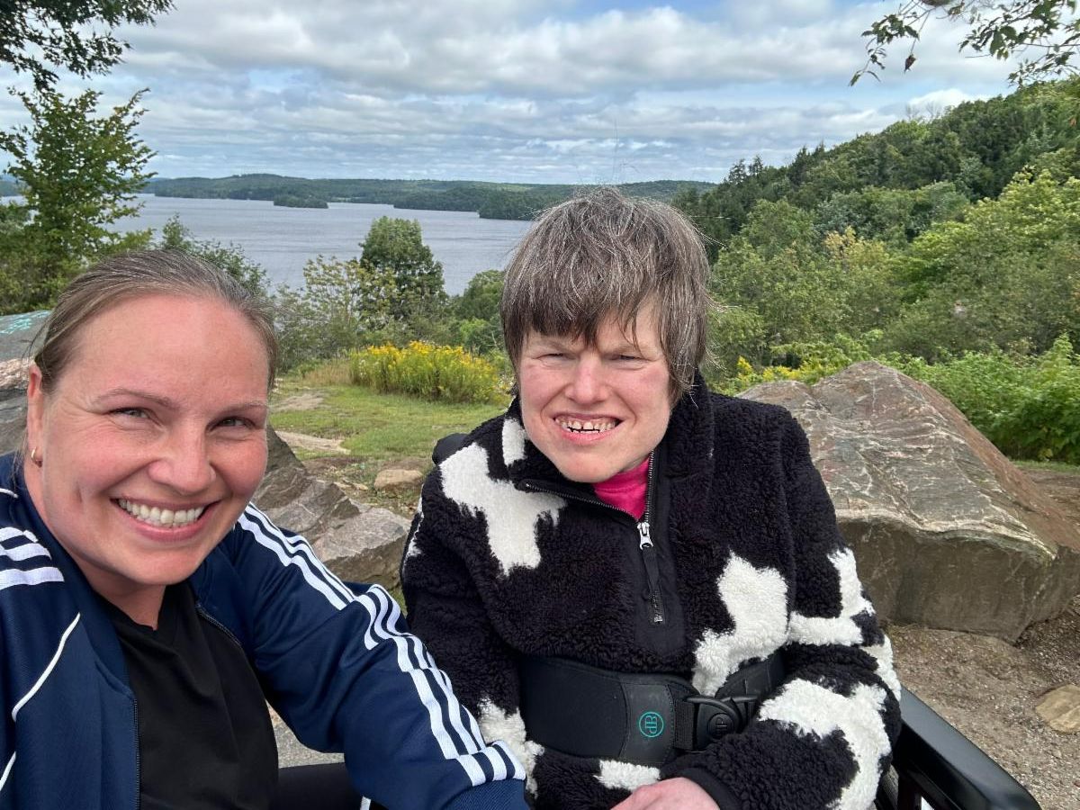 2 women take a selfie with a lake in the background