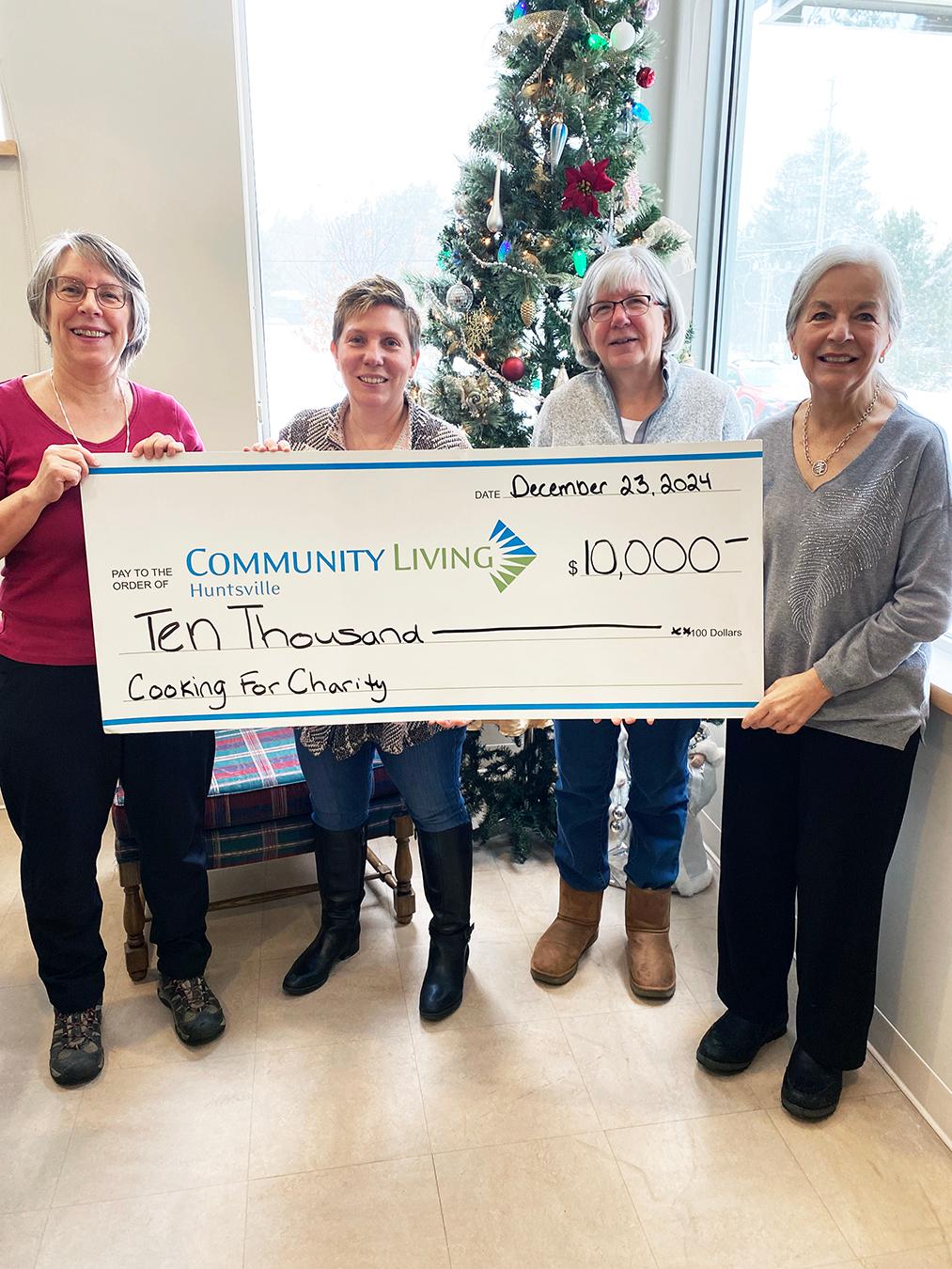 4 women holding a large presentation cheque for 10 thousand dollars