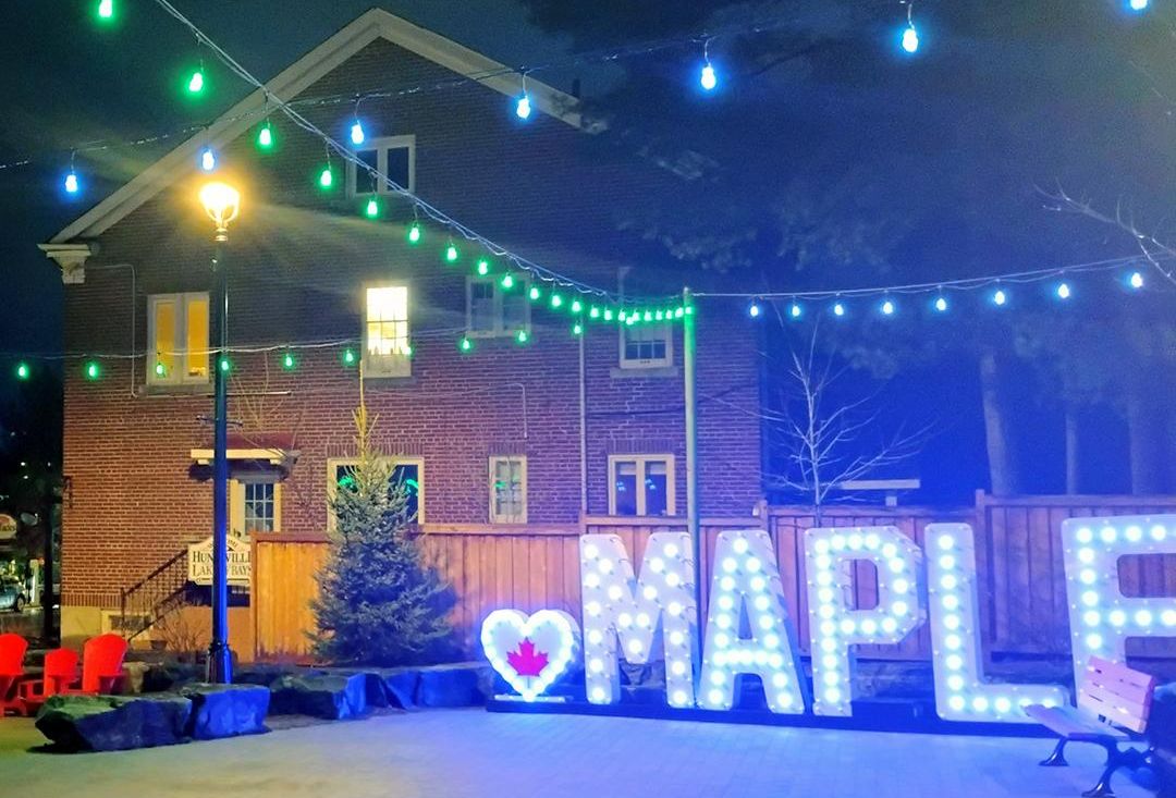 Huntsville Kent Park lit at night with a neon blue sign that reads Maple