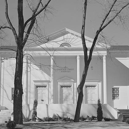classic architecture church with two trees in foreground in black and white