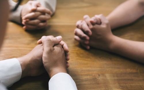 Christian and prayer. Christian group of people holding hands praying worships together to believe and Bible on a wooden table for devotional for prayer meeting concept.