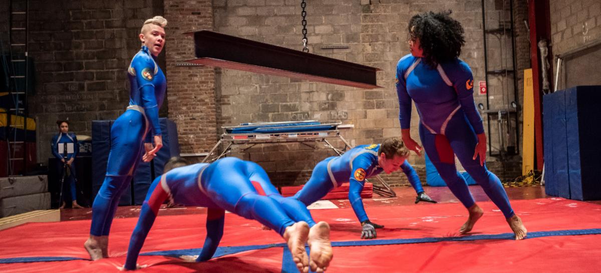 Dancers dodge a steel I-beam. 