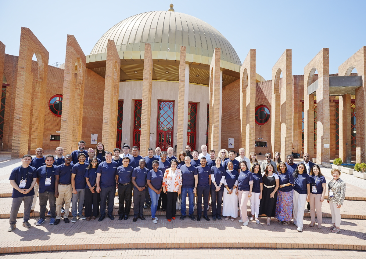 ICANN86 Fellowship Program leaders and participants gather for a group photo in front of the FIBES Conference and Exhibition Centre in Seville, Spain, during the ICANN86 Policy Forum.