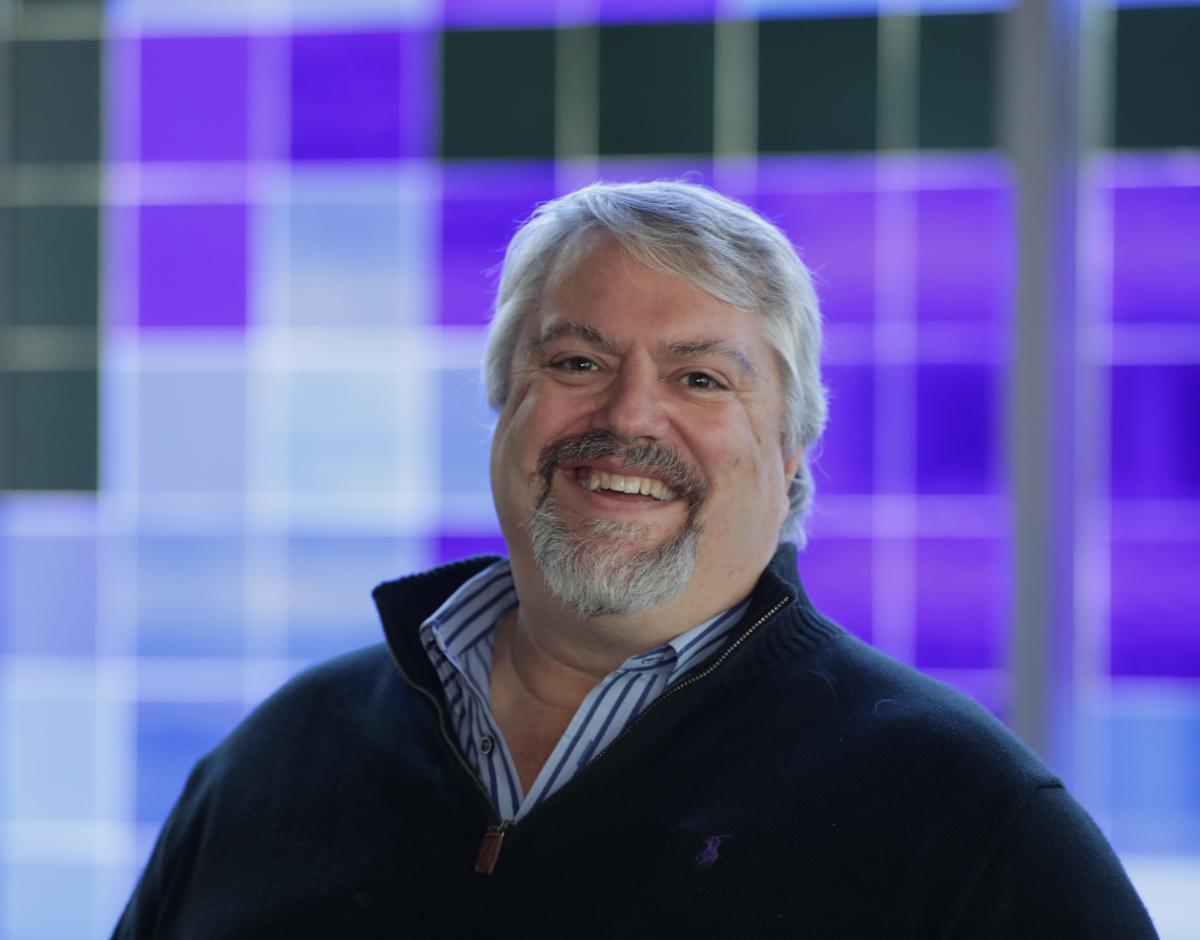 Jonathan Zuck - Chair, At-Large Committee (ALAC). He's smiling in front on a blue, purple, and black mosaic background.