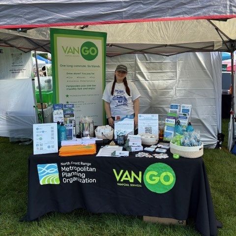One NFRMPO Staff member standing behind a booth at an outreach event. 