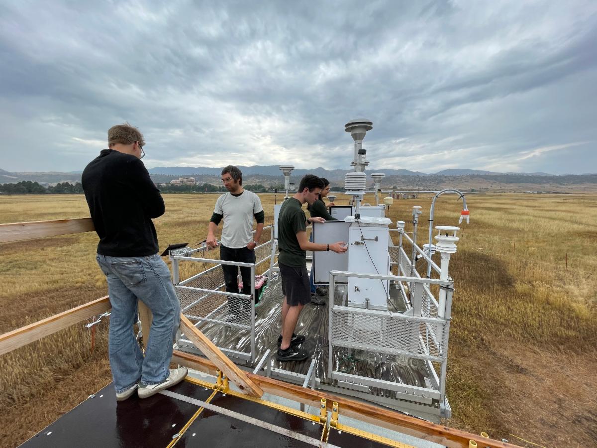 CSU graduate students Andrey Marsavin Brandon McGuire Jared Stickney and Dani Guevara check equipment on the roof of the mobile laboratory at Christman Field at the Fort Collins-West site. Photo by Jenn Fields for the Regional Air Quality Council.