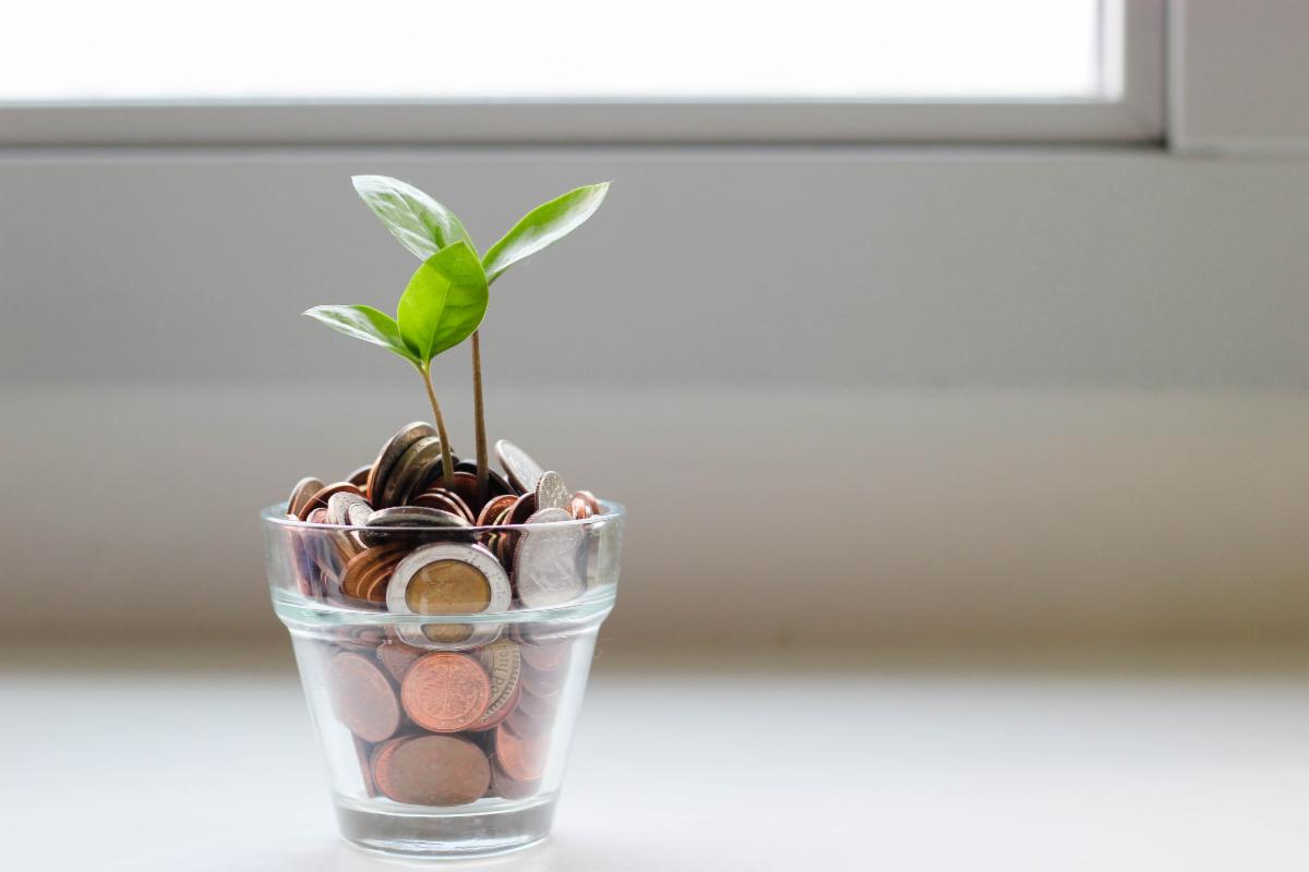 photo of jar full of coins on top of table.