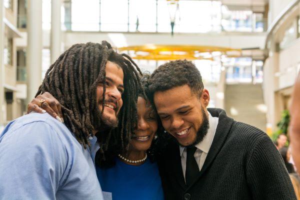 Family embraces at naturalization ceremony